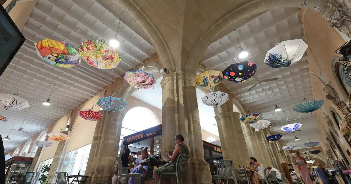 Cincuenta y tres paraguas convertidos en arte llenan de color y reflexión el mercado de Maó