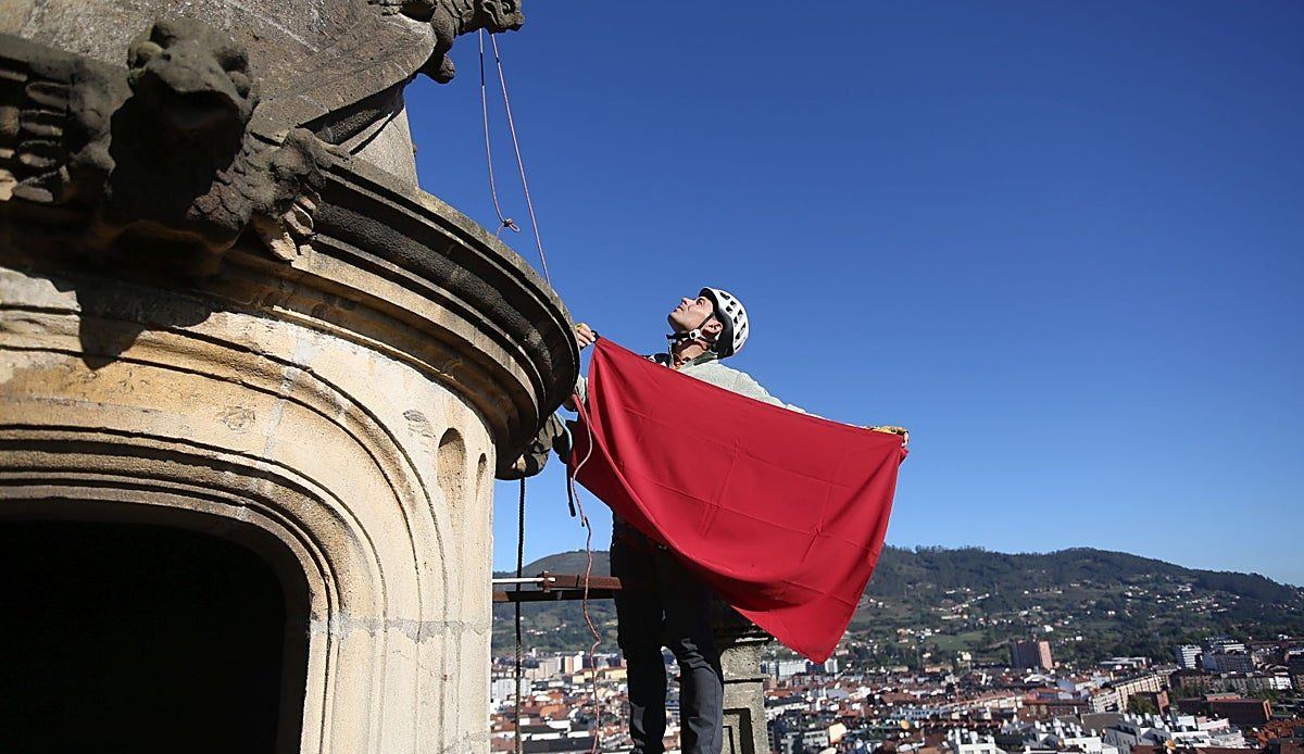 Oviedo se viste de Perdonanza: el escalador Joaquín Álvarez coloca las banderas del Jubileo a 85 metros de altura en la Cated