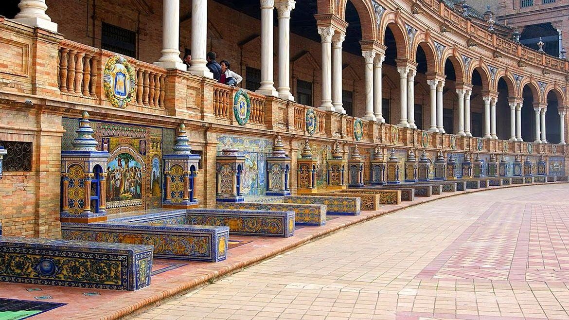 Obras del Gobierno en la Plaza de España dejan materiales apilados sobre los bancos cerámicos sin protección